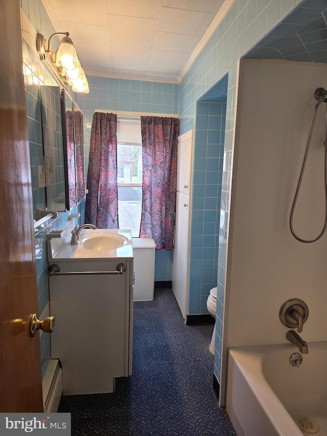 full bathroom with tile walls, vanity, toilet, and  shower combination