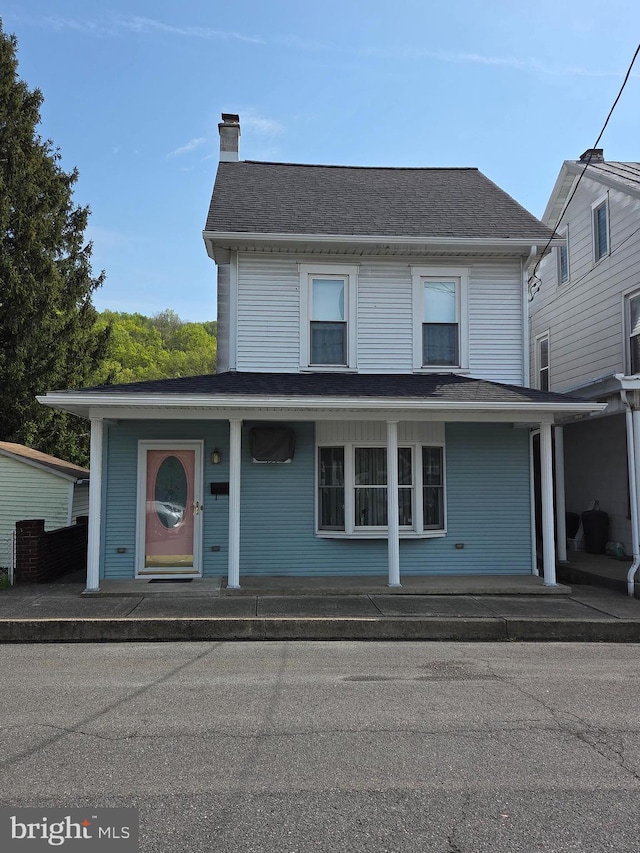view of front of home with covered porch and a chimney