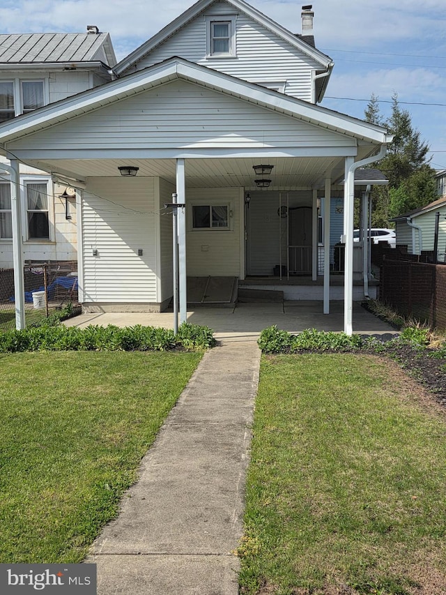 view of front facade featuring a porch, fence, a chimney, and a front lawn