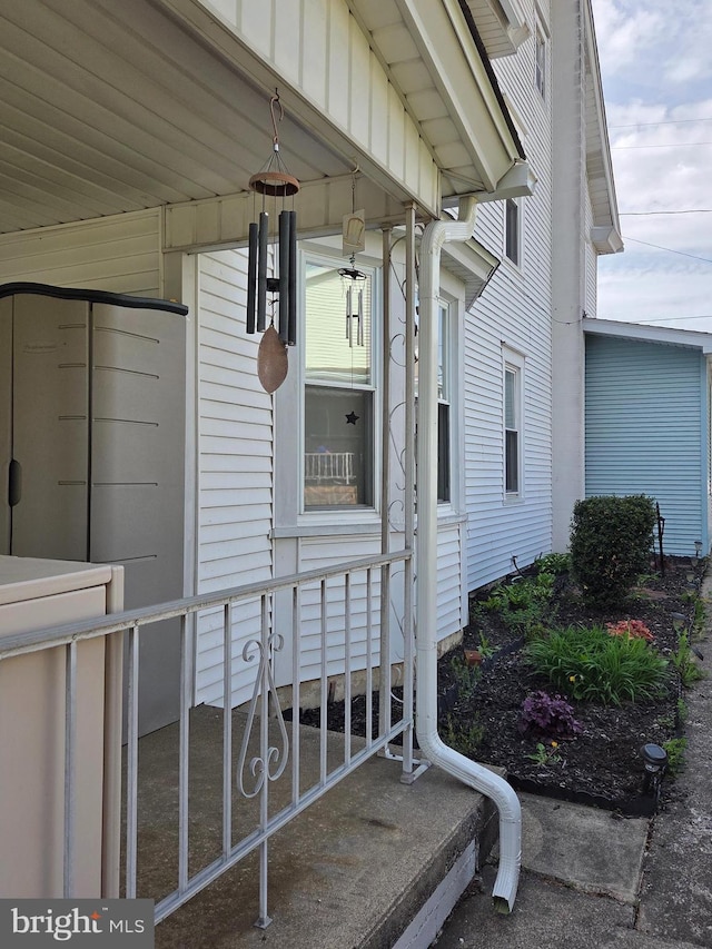 doorway to property with board and batten siding and a porch