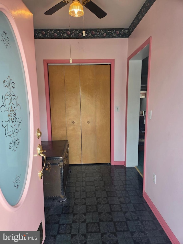 foyer featuring ceiling fan and baseboards
