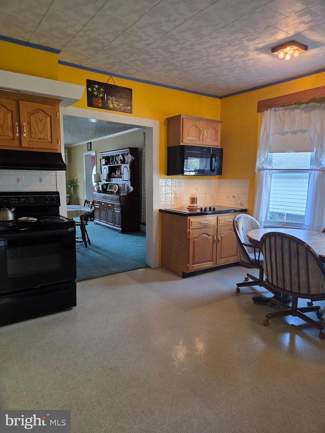 kitchen with light colored carpet, tasteful backsplash, brown cabinets, black appliances, and under cabinet range hood
