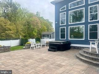 view of patio featuring fence and a hot tub