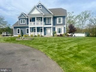 view of front facade featuring a front yard and a balcony