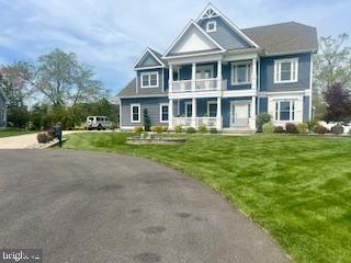 view of front of house with a balcony and a front yard