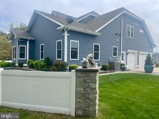 rear view of house with a lawn and fence