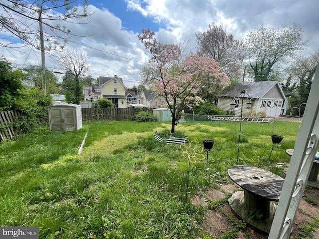 view of yard featuring an outbuilding, a storage unit, and a fenced backyard