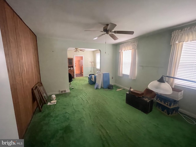 interior space with baseboards, visible vents, ceiling fan, and carpet floors