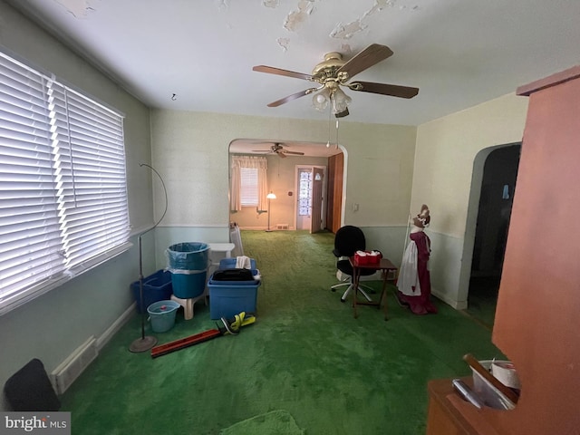 interior space with a wealth of natural light, baseboards, arched walkways, and a ceiling fan