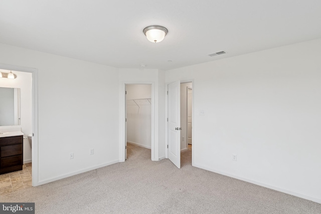 199 Holstein Dr Unit 117, Hanover, PA 17331 - unfurnished bedroom featuring visible vents, light carpet, a walk in closet, and a closet