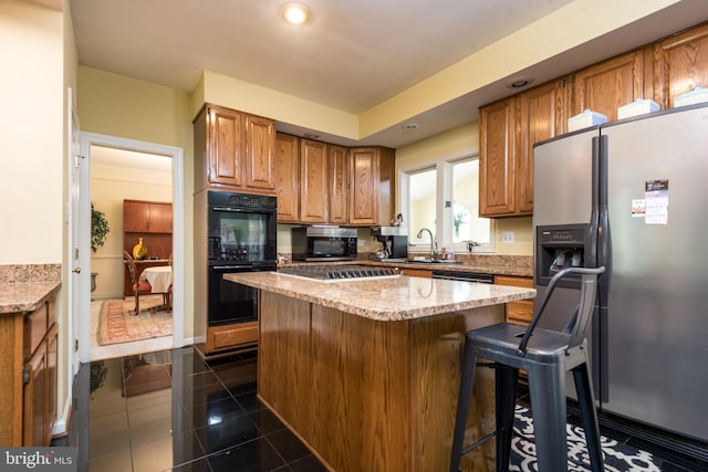 kitchen with brown cabinets, a sink, appliances with stainless steel finishes, a kitchen island, and recessed lighting