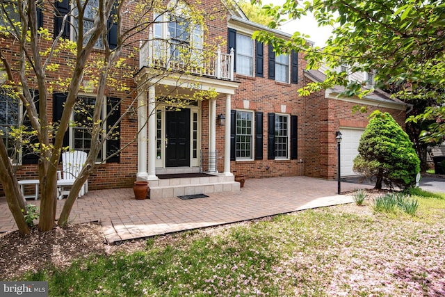 rear view of house featuring brick siding and a balcony