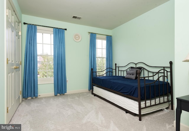 bedroom with visible vents, carpet flooring, multiple windows, and baseboards