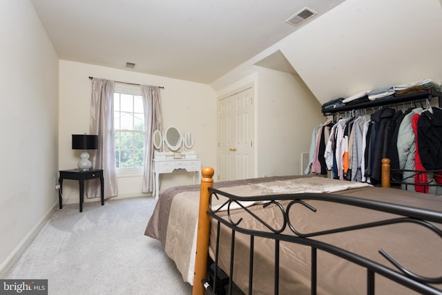 bedroom with visible vents, light carpet, and baseboards