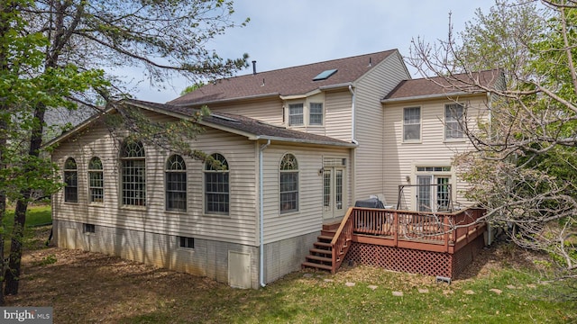 rear view of property featuring a deck and a lawn
