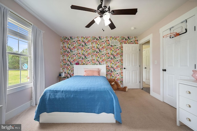 bedroom with visible vents, an accent wall, carpet flooring, baseboards, and wallpapered walls