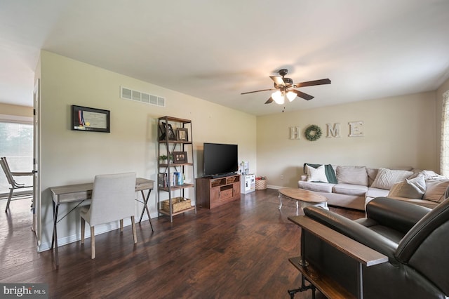 living room featuring dark wood-style flooring, baseboards, a ceiling fan, and visible vents