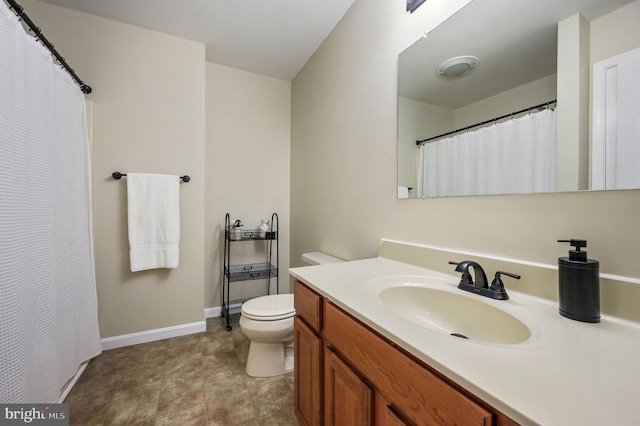 bathroom with toilet, baseboards, and vanity