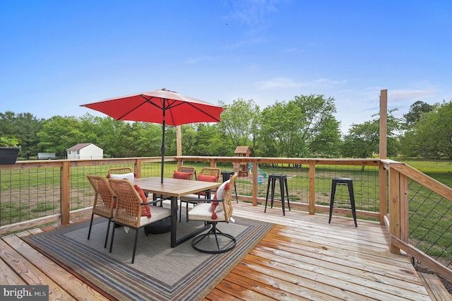 wooden deck with a yard and outdoor dining area