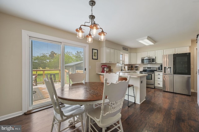 dining space featuring baseboards, dark wood-style flooring, and an inviting chandelier