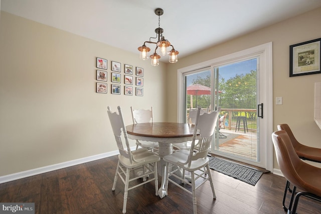 dining space with a chandelier, baseboards, and wood finished floors
