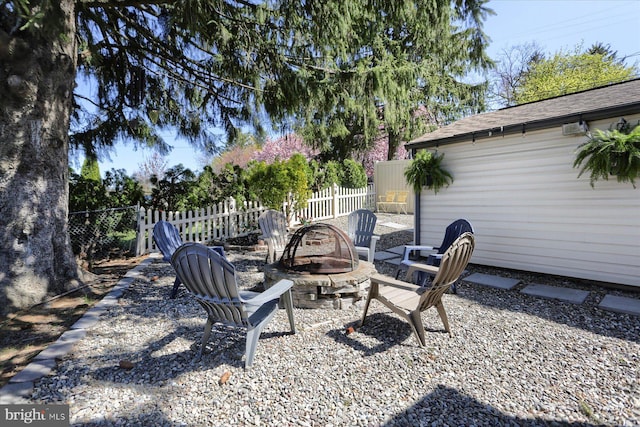view of yard with fence and an outdoor fire pit