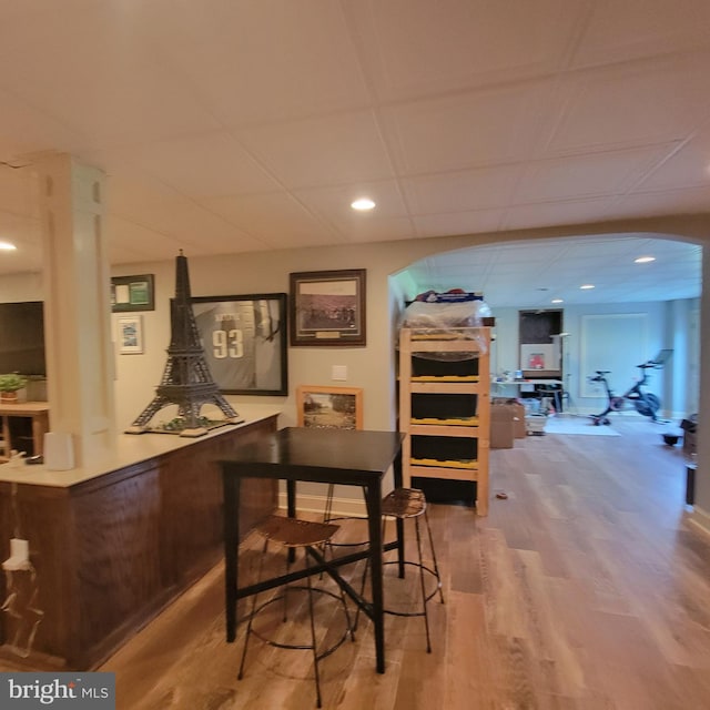 bar with wood finished floors and arched walkways