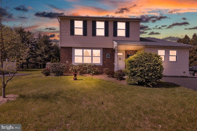traditional home with a front yard and brick siding