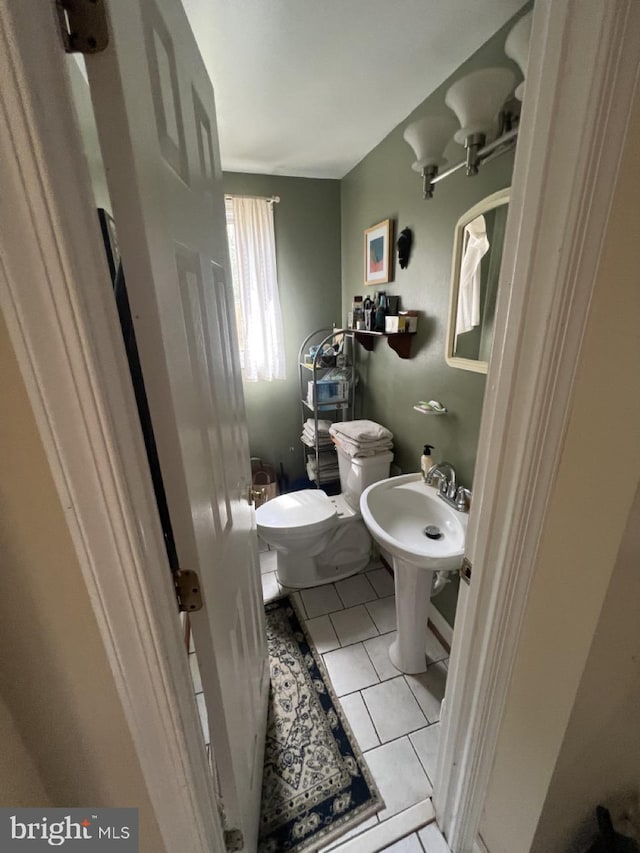 half bath with tile patterned floors and toilet