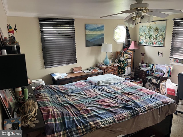 carpeted bedroom featuring ornamental molding and a ceiling fan
