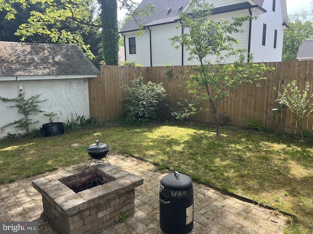 view of yard featuring a patio, a fenced backyard, and a fire pit