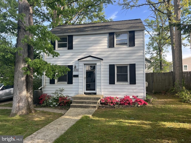 view of front of home featuring fence and a front lawn