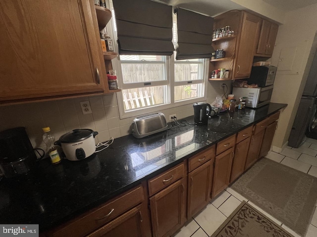 kitchen featuring brown cabinetry, open shelves, light tile patterned floors, and tasteful backsplash