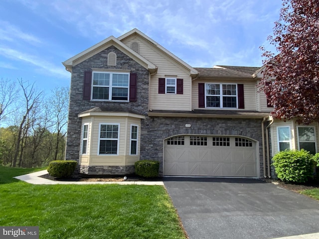view of front of property with a garage, a front lawn, aphalt driveway, and stone siding
