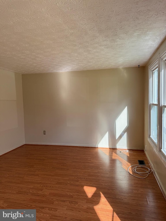 22 Morning Ct, Rosedale, MD 21237 - spare room with visible vents, a wealth of natural light, a textured ceiling, and wood finished floors