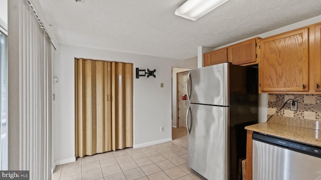 412 Trimblefields Dr, Edgewood, MD 21040 - kitchen featuring appliances with stainless steel finishes, light tile patterned floors, baseboards, light countertops, and a textured ceiling