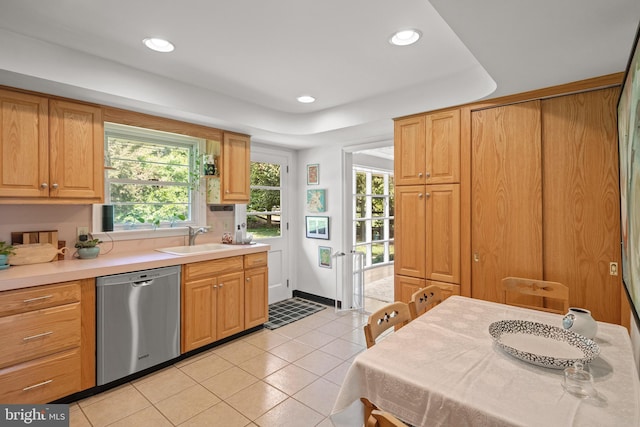 kitchen with dishwasher, a sink, light tile patterned floors, light countertops, and recessed lighting