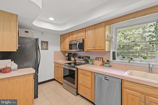 kitchen featuring a sink, light countertops, stainless steel appliances, recessed lighting, and light tile patterned floors