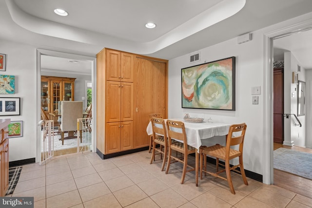 dining space with recessed lighting, baseboards, light tile patterned floors, a tray ceiling, and visible vents
