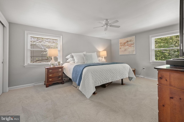 bedroom featuring baseboards, ceiling fan, and light carpet