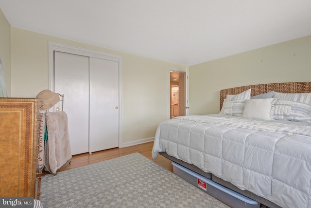 bedroom with a closet, baseboards, and wood finished floors
