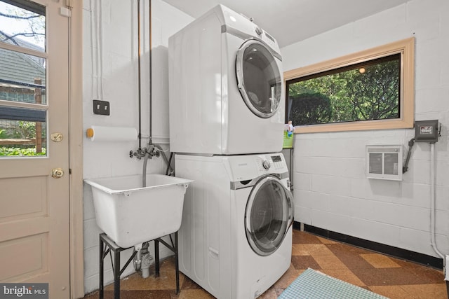 clothes washing area with a healthy amount of sunlight, laundry area, stacked washer and dryer, visible vents, and tile patterned floors