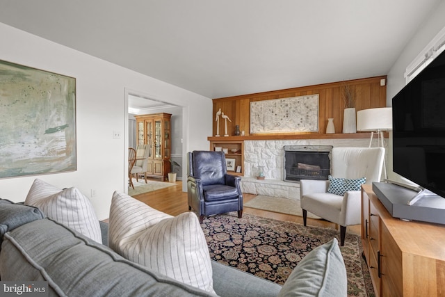 living room with baseboards, wood finished floors, and a fireplace