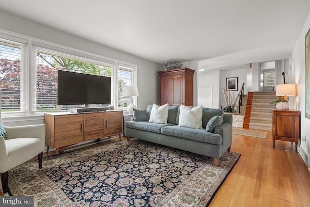 living room featuring wood finished floors and stairway