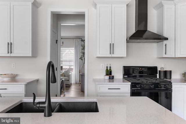 194 Cool Springs Road, North East, MD 21901 - kitchen with white cabinetry, black gas range, wall chimney exhaust hood, and a sink