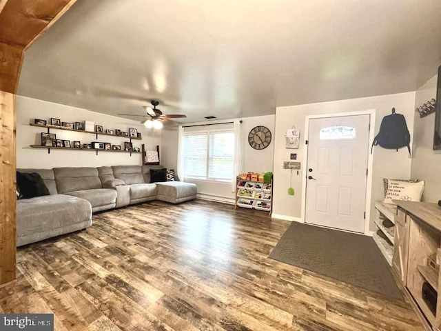 living area with dark wood-style flooring, a ceiling fan, and baseboards