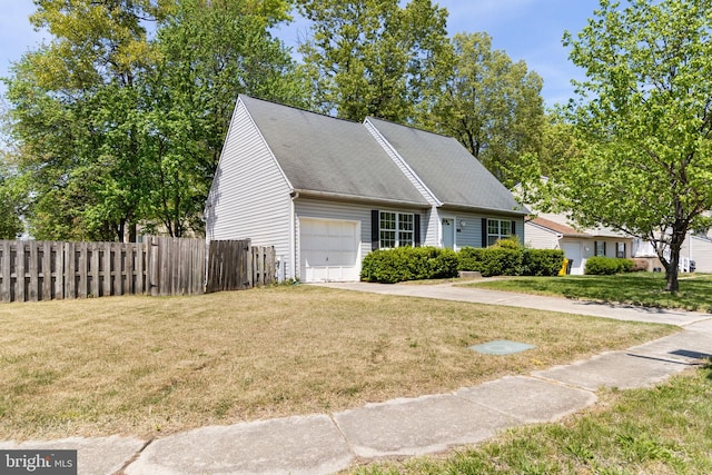 view of front facade featuring an attached garage, fence, and a front lawn