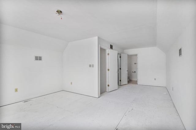 additional living space featuring visible vents and lofted ceiling