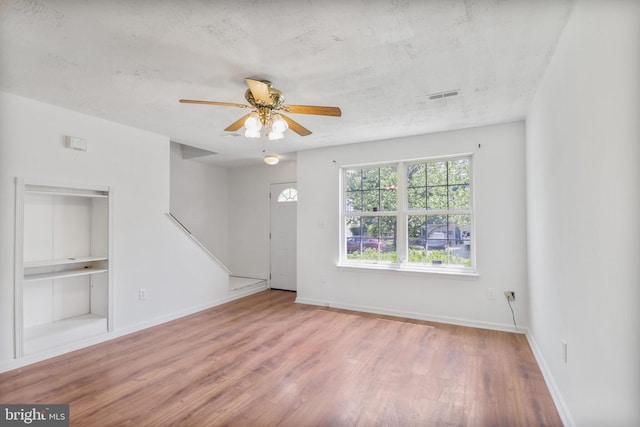 interior space with visible vents, baseboards, ceiling fan, and wood finished floors