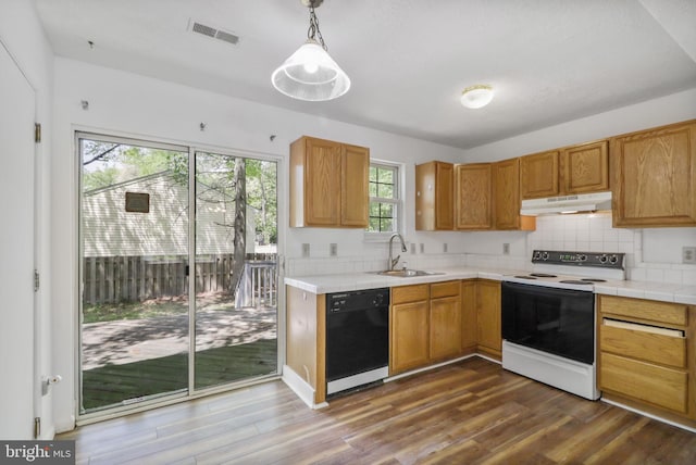 kitchen featuring white range with electric stovetop, a sink, dishwasher, under cabinet range hood, and visible vents